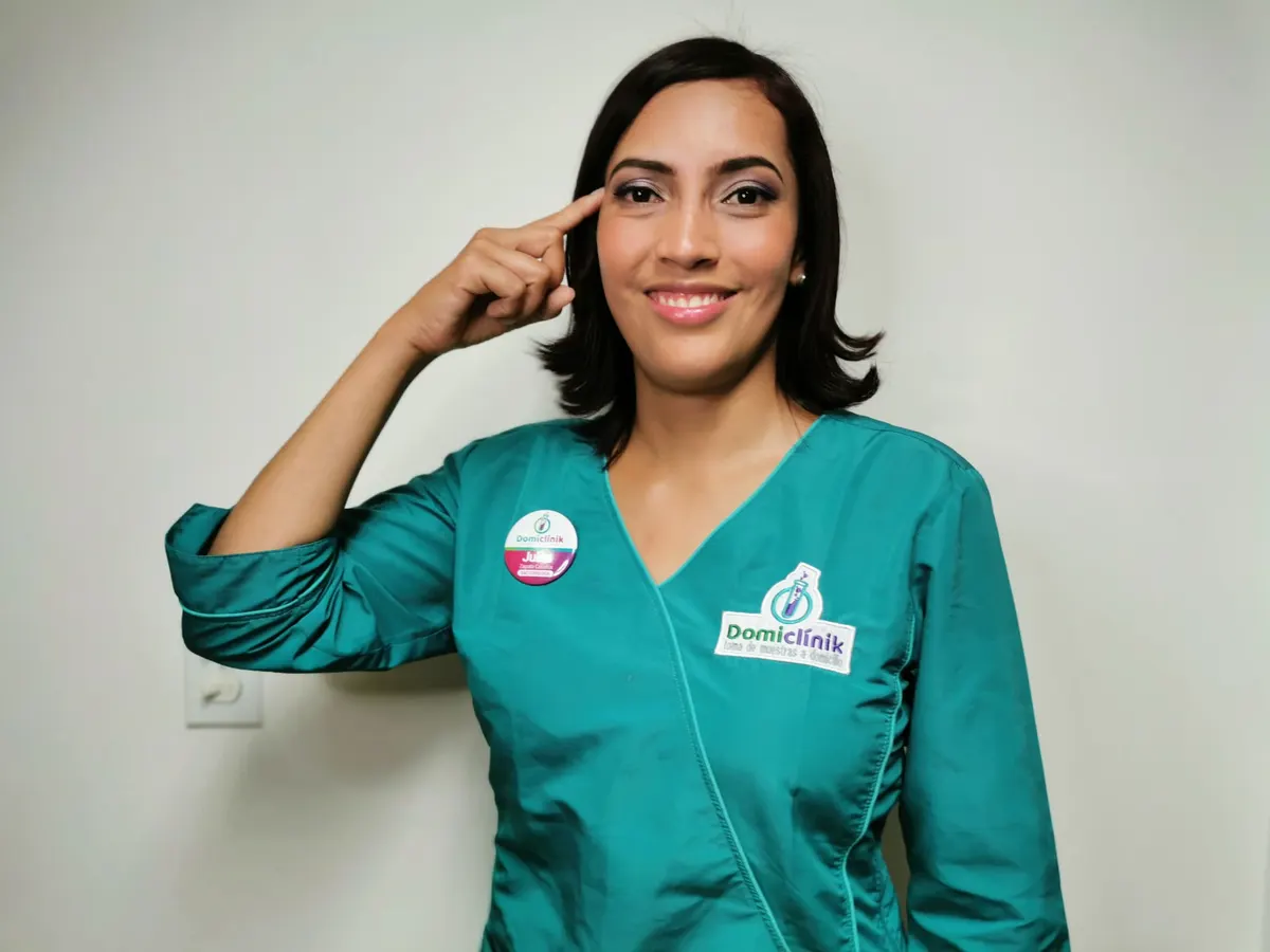 Profesional de DomiClinik con uniforme turquesa y escarapela de identificación institucional